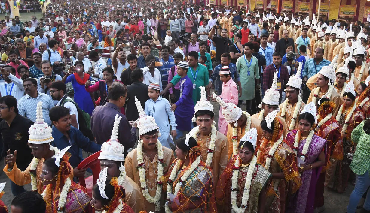 Iring-iringan calon pasangan pengantin di India saat mengikuti upacara pernikahan massal di Kolkata (14/2). Acara nikah massal ini diselenggarakan oleh LSM setempat yang bertujuan untuk merayakan Hari Valentine. (AFP Photo/Dibyangshu Sarkar)