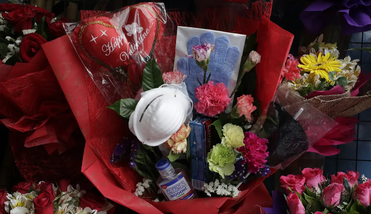 Paket rangkaian bunga Valentine di Alabang, Manila, Filipina (13/2/2020). Pemilik toko Mary Jane Villegas sengaja meletakkan keperluan perlindungan terhadap COVID-19 di karangan bunga untuk mengingatkan, bunga bukan satu-satunya yang dapat diberikan saat Valentine. (AP Photo/Aaron Favila)