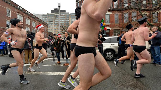 Pelari berjalan menyusuri Newbury Street selama Santa Speedo Run di Boston, Massachusetts, Sabtu (14/12/2019). Acara yang menjadi tradisi tahunan  tersebut bertujuan untuk mengumpulkan donasi untuk membantu anak-anak setempat yang membutuhkan. (Joseph Prezioso/AFP)