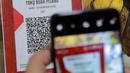QRIS adalah standar kode QR (Quick Response) yang digunakan di Indonesia untuk menghubungkan dompet digital dan metode pembayaran non-tunai dengan berbagai pihak, termasuk bank dan pedagang. (Liputan6.com/Johan Tallo)