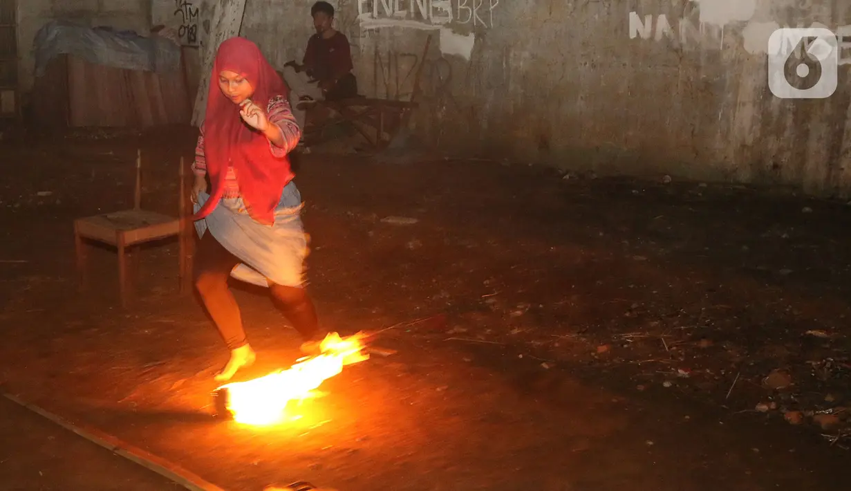 Seorang wanita saat bermain bola api di Kawasan Rempoa, Tangerang Selatan, Rabu (19/08/2020). Bermain Bola api tersebut dilakukan dalam rangka menyambut peringatan tahun baru Islam 1 Muharram 1442 H. (Liputan6.com/Herman Zakharia)