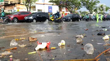 Pengendara melintasi jalan Margonda Raya yang tergenang air, Kota Depok, Jawa Barat, Jumat (29/5/2020). Hujan deras dan tersumbatnya aliran air menyebabkan sebagian ruas jalan Margonda Raya sempat tergenang air serta menyebabkan arus lalu lintas tersendat. (LIputan6.com/Helmi Fithriansyah)