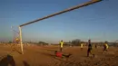 Seorang kiper melihat bola yang masuk ke gawangnya saat bermain pada pertandingan persahabatan di lapangan yang berdebu di Soweto, Afrika Selatan, Rabu (16/6/2021).  (AP Photo/Themba Hadebe)