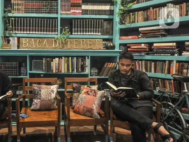 Pengunjung membaca buku di perpustakaan Baca Di Tebet, Tebet, Jakarta Selatan, Minggu (29/5/2022). Perpustakaan Baca Di Tebet yang didirikan pada Februari lalu menjadi alternatif bagi warga yang membutuhkan ruang literasi dan diskusi dengan suasana nyaman sekaligus meningkatkan minat baca bagi generasi milenial yang dilengkapi sekitar 25.000 buku. (merdeka.com/Iqbal S Nugroho)