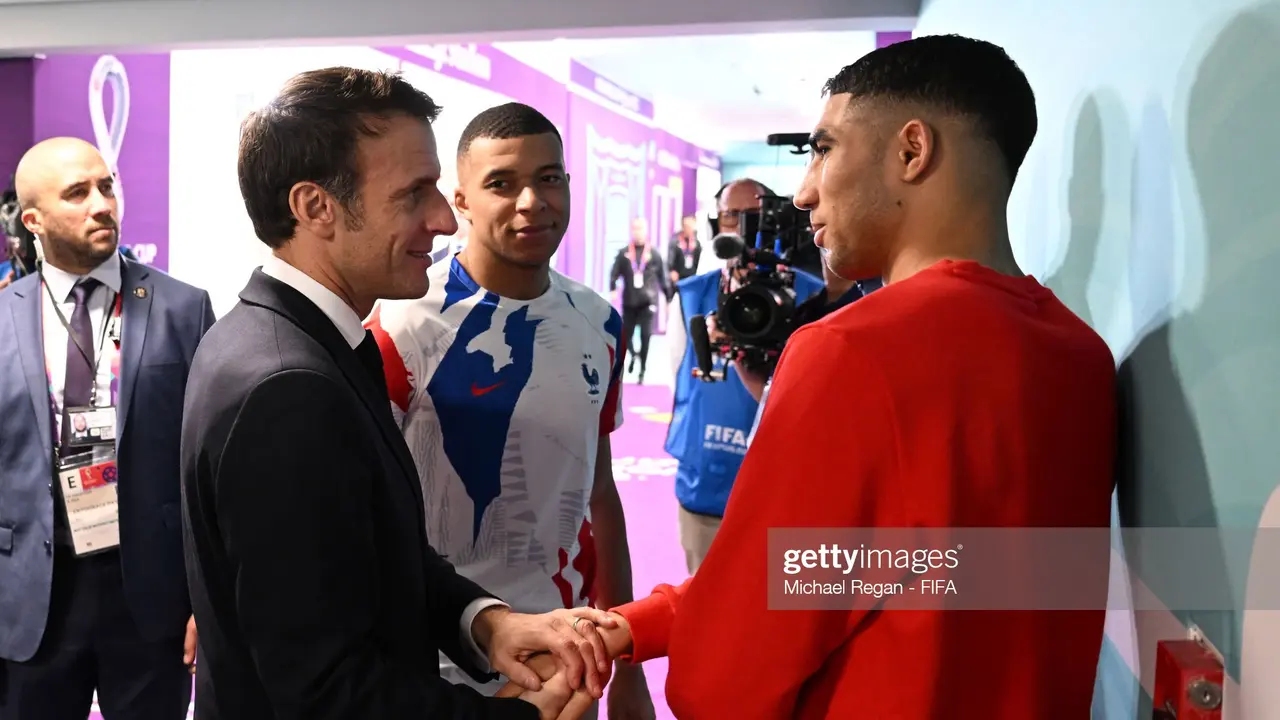 Emmanuel Macron berbicara dengan Kylian Mbappe dari Prancis dan Achraf Hakimi dari Maroko usai pertandingan semifinal Piala Dunia 2022.