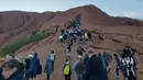Selebaran yang diterima pada 10 Oktober 2019 memperlihatkan para wisatawan mendaki Uluru di Utara Australia.  Heboh rencana penutupan memicu gelombang kedatangan pengunjung demi merasakan pengalaman mendaki titik yang selama ini dikenal dengan sebutan Ayers Roc tersebut. (HO/ @koki_mel_aus/AFP)
