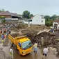 Tim SAR Gabungan menggunakan alat berat membersihkan sisa material banjir bandang di Desa Bulukerto, Kota Batu pada Jumat, 5 November 2021 (Liputan6.com/Zainul Arifin)