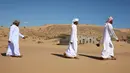 Mantan penduduk Wadi al-Murr berjalan dekat rumah-rumah terlantar di Desa Omani, Wadi al-Murr, Oman, 31 Desember 2020. Pasir yang menggunung hanya menyisakan sedikit bukti bahwa Desa Omani pernah ada di Wadi al-Murr, Oman. (MOHAMMED MAHJOUB/AFP)