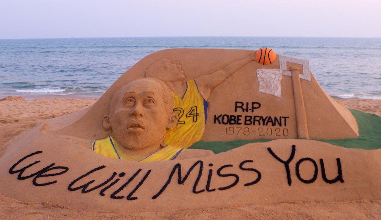 Seniman India, Sudarsan Pattnaik, membuat ukiran dari pasir untuk mengenang Kobe Bryant di Bhubaneswar, India, Senin (27/1). Akibat kecelakaan helikopter, legenda NBA itu wafat bersama sang putri. (AFP/Stringer)
