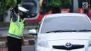 Petugas kepolisian mengarahkan kendaraan saat pengalihan arus di Jalan Jenderal Sudirman, Jakarta, Minggu (31/12). Pengalihan terkait malam puncak perayaan pergantian tahun di kawasan Bundaran HI hingga Jalan MH Thamrin. (Liputan6.com/Helmi Fithriansyah)