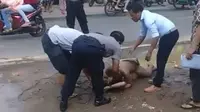 Pasangan pria yang telanjang yang digrebek dari sebuah mobil di Pati, diikat oleh warga disaksikan polisi. (foto: Liputan6.com/istimewa/felek wahyu)