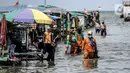 Petugas PPSU membersihkan sampah saat terjadi banjir rob di Pelabuhan Kali Adem, Muara Angke, Jakarta, Selasa (9/11/2021). Walau terendam banjir rob, petugas PPSU tetap sigap bersihkan sampah yang mengambang terbawa air laut. (Liputan6.com/Faizal Fanani)