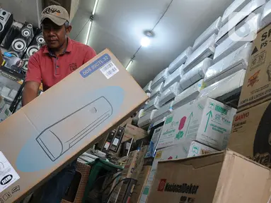 Pedagang memindahkan pendingin udara (Air Conditioner) di salah satu toko, Kawasan Pasar Kramat Jati, Jakarta, Rabu (6/9/2023). (merdeka.com/Imam Buhori)
