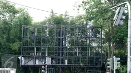 Pekerja memperbaiki papan reklame di Kawasan Senayan Jakarta, Kamis, (6/10). Papan reklame diremajakan agar tidak roboh diterpa hujan deras disertai angin kencang. (Liputan6.com/Gempur M. Surya)