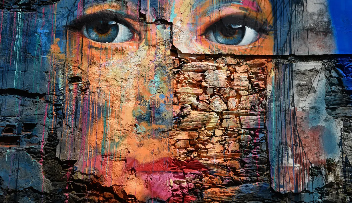 Sebuah mural wajah manusia terlihat selama festival seni jalanan tahunan Meninas de Canido di Ferrol, Spanyol, Minggu (2/9). Meninas de Canido didirikan pada tahun 2008. (MIGUEL RIOPA/AFP)