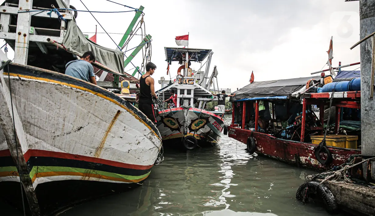 Nelayan beraktivitas di perahu saat bersandar di Pelabuhan Muara Angke, Jakarta, Senin (26/12/2022). Akibat angin  barat dan gelombang tinggi menyebabkan nelayan tradisional di Muara Angke libur melaut. (Liputan6.com/Faizal Fanani)