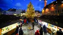 Seorang pria berjalan dengan seekor anjing di Pasar Natal di Alun-Alun Balai Kota, Tallinn, Estonia, 24 Desember 2022. (AP Photo/Pavel Golovkin)
