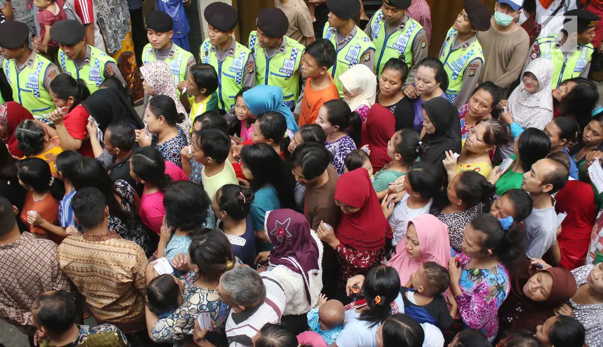 Aparat kepolisian disiagakan saat pembagian paket sembako Ramadan dari BUMN di Kecamatan Penjaringan, Jakarta, Selasa (13/6). Sebanyak 14 perusahaan BUMN yang turut serta dalam acara pembagian paket sembako se-Jabodetabek ini. (Liputan6.com/Angga Yuniar)