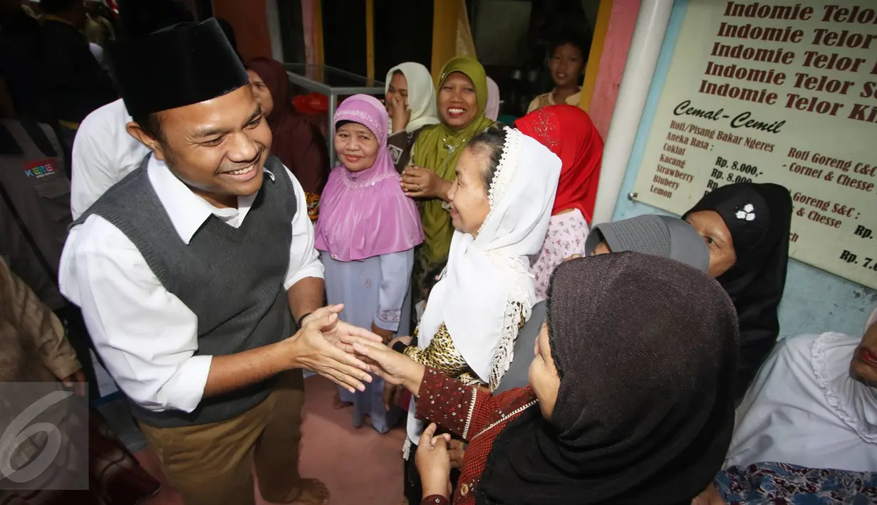 Bakal Calon Gubernur DKI dari PKS Muhamad Idrus bersalaman dengan warga saat menghadiri buka puasa dan santunan anak yatim di Kebon Sirih, Jakarta, Sabtu (18/6). Buka bersama tersebut dalam rangka menjalin silaturahmi. (Liputan6.com/Immanuel Antonius)