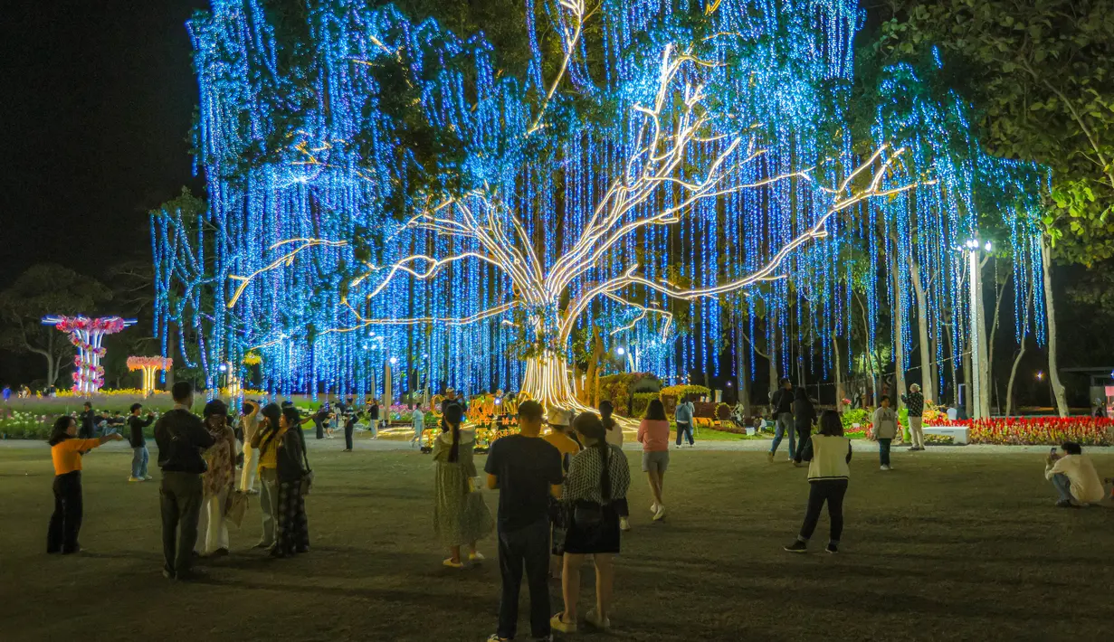 Acara ini menampilkan pameran bunga, instalasi cahaya, dan pertunjukan budaya yang spektakuler untuk mempromosikan pariwisata lokal. Tampak dalam foto, pengunjung menikmati suasana Charming Chiang Mai Flower Festival di Chiang Mai, Thailand, pada Kamis (11/12/2025). (Bola.com/Bagaskara Lazuardi)