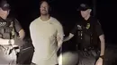 Dalam gambar yang diambil dari video terlihat pegolf ternama AS, Tiger Woods ditangkap dua polisi di Jupiter, Florida, 29 Mei 2017. Tiger Woods harus berurusan dengan pihak kepolisian karena menyetir dalam keadaan mabuk. (Jupiter Police Department/via AP)