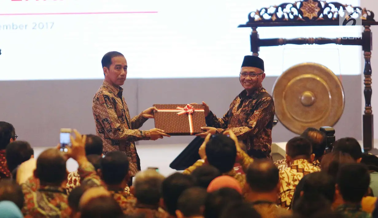 Presiden Jokowi menerima cenderamata dari Ketua KPK, Agus Rahardjo pada peringatan hari Antikorupsi Dunia, Jakarta, Senin (11/12). (Liputan6.com/Angga Yuniar)
