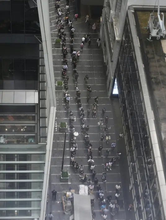 Orang-orang antre untuk edisi terakhir Apple Daily di stan surat kabar di jalan pusat kota di Hong Kong, Kamis (24/6/2021). Sebelumnya, kantor surat kabar itu igerebek polisi dan pemilik beserta lima eksekutifnya ditangkap di bawah undang-undang keamanan nasional yang baru. (AP Photo/Vincent Yu)