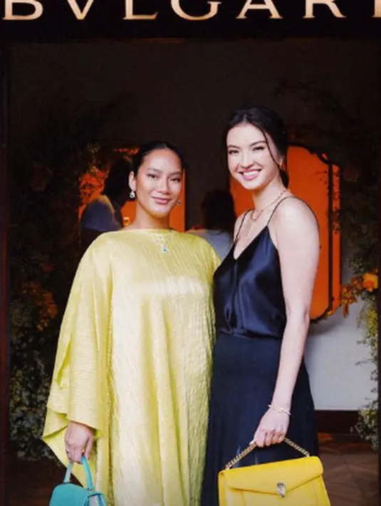 Raline Shah tampil dengan two piece satin dress. Ia memadukan tank top satin berwarna hitam dengan flowy skirt yang cantik. Raline Shah pun menenteng tas Serpenti East-West Maxi Chain Shoulder Bag berwarna kuning seharga Rp38,9 jutaan. (instagram/tarabasro)
