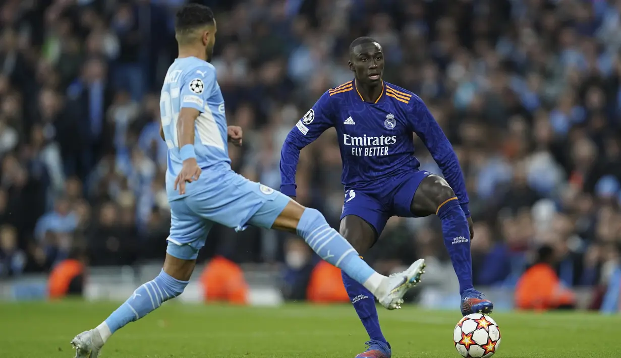 <p>Bek Real Madrid, Ferland Mendy mengontrol bola dari kawalan gelandang Manchester City, Riyad Mahrez&nbsp;pada pertandingan leg pertama semifinal Liga Champions di stadion Etihad di Manchester, Inggris, Rabu (27/4/2022). City menang atas Madrid 4-3. (AP Photo/Jon Super)</p>