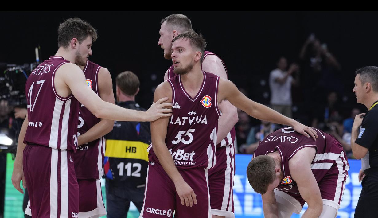 Pebasket Latvia, Arturs Zagars (tengah) memberikan semangat kepada rekannya, Davis Bertrans (kanan) setelah kalah dari Jerman pada laga perempat final Piala Dunia FIBA 2023 di Mall of Asia Arena, Manila, Filipina pada Rabu (06/09/2023). (AP Photo/Michael Conroy)