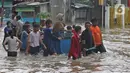 Warga menggunakan jasa gerobak untuk menghindar banjir yang merendam Jalan Pondok Raya Gede, Jakarta Timur, Selasa (25/2/2020).  Sejumlah ruas jalan tergenang dan akses ke beberapa wilayah terputus, salah satunya Jalan Pondok Raya Gede. (Liputan6.com/Herman Zakharia)