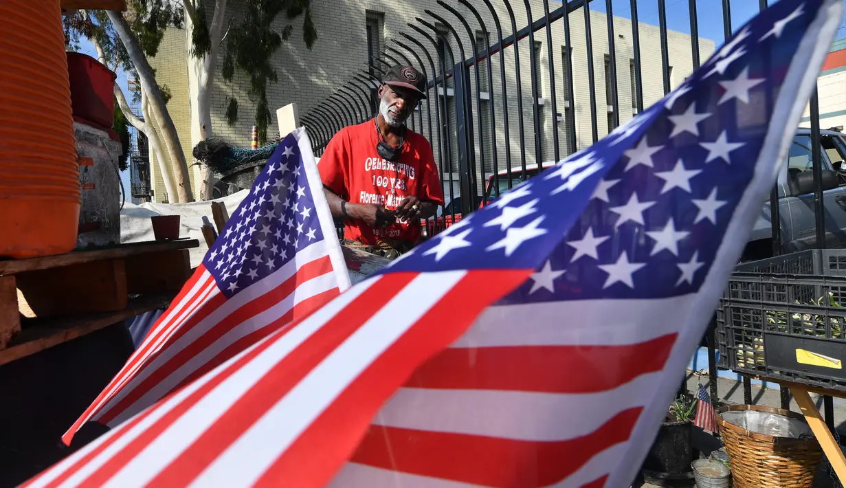 Bendera Amerika Serikat (AS) dikibarkan di tempat tinggal veteran yang bernama Kendrick Bailey di Los Angeles, California (10/11). Kendrick Bailey merupakan veteran AS yang pernah bertugas di Vietnam. (AFP Photo/Frederic J. Brown)