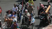 Seorang turis mengabadikan gambar dari atas becak saat mengelilingi alun alun Kraton Kesultanan Yogyakarta, (4/5). Becak menjadi transportasi ramah lingkungan yang di minati wisatawan karena tidak menimbulkan polusi udara. (Liputan6.com/Boy Harjanto)