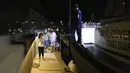 Orang-orang menunggu untuk dievakuasi dengan perahu setelah kebakaran hutan mencapai Pembangkit Listrik Kemerkoy di Milas di barat daya Turki, Rabu (4/8/2021) malam. Pembangkit listrik Kemerkoy merupakan Pembangkit listrik berbahan bakar batu bara. (AP Photo/Cem Tekkesoglu)