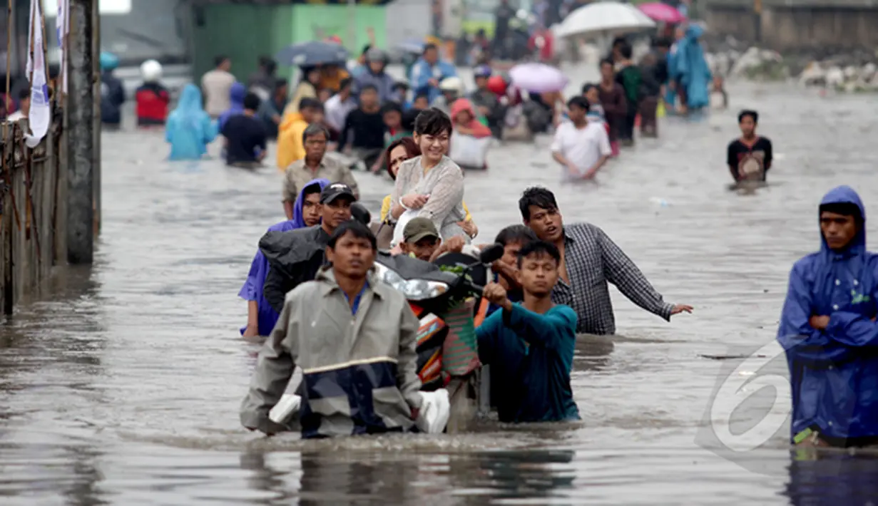 Sejumlah warga terpaksa menggunakan jasa gerobak untuk melintasi banjir yang setinggi dada orang dewasa di Jalan Gunung Sahari, Jakarta, Senin (6/2/2015). (Liputan6.com/Faizal Fanani)