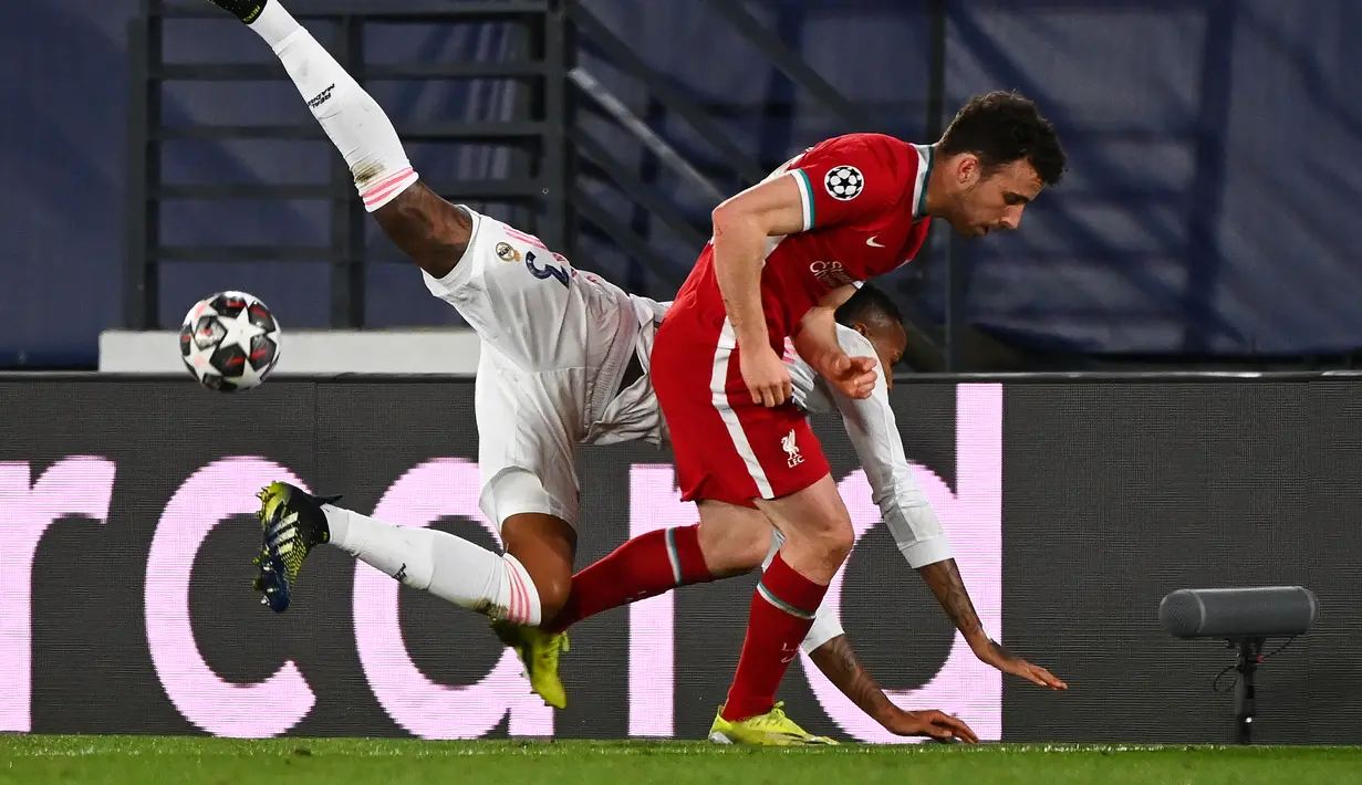 Bek Real Madrid, Eder Militao (kiri) menantang striker Liverpool, Diogo Jota pada leg pertama perempatfinal Liga Champions di Estadio Alfredo Di Stefano, Rabu (7/4/2021) dini hari WIB. Real Madrid makin dekat ke semifinal Liga Champions usai menang 3-1 atas Liverpool. (GABRIEL BOUYS / AFP)