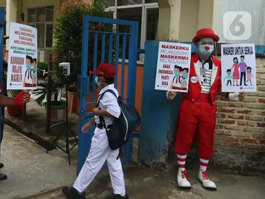 Seniman Aku Badut Indonesia (ABI) mengkampanyekan memakai masker di SDN 03 Citayam, Kabupaten Bogor, Jawa Barat, Senin (6/9/2021). Aksi tersebut tentang protokol kesehatan serta membagikan masker kepada anak-anak sekolah yang menggelar Pembelajaran Tatap Muka (PTM). (Liputan6.com/Herman Zakharia)