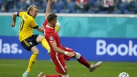 Gelandang Swedia, Emil Forsberg (kiri) melepaskan tembakan yang berbuah gol ke gawang Polandia dalam laga Grup E Euro 2020 di Saint Petersburg Stadium, St Petersburg, Rabu (23/6/2021) malam WIB. (Foto: AP/Pool/Dmitri Lovetsky)