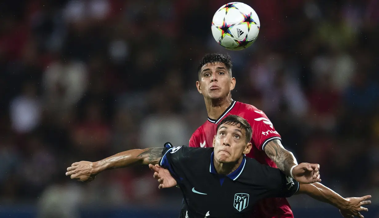 Bek  Bayer Leverkusen Piero Hincapie berebut bola dengan bek Atletico Madrid Nahuel Molina dalam matchday kedua Grup B Liga Champions di BayArena, Rabu (14/9/2022) dini hari WIB. Bertandang ke markas Bayer Leverkusen, Atletico Madrid tumbang dengan skor 0-2. (Marius Becker/dpa via AP)