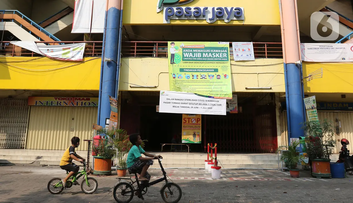Anak-anak bermain sepeda di area Pasar Tomang Barat, Jakarta, Senin (29/06/2020). Pasar Tomang Barat atau yang lebih dikenal dengan sebutan Pasar Kopro itu ditutup mulai 29 Juni hingga 1 Juli setelah ada pedagang yang dinyatakan positif Covid-19 dari hasil tes usap. (Liputan6.com/Herman Zakharia)