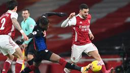Gelandang Arsenal, Dani Ceballos (kanan) berebut bola dengan striker Crystal Palace, Wilfried Zaha dalam laga lanjutan Liga Inggris 2020/21 di Emirates Stadium, Kamis (14/1/2021). Arsenal bermain imbang 0-0 dengan Crystal Palace. (AFP/Neil Hall/Pool)
