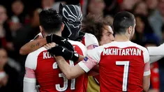 Striker Arsenal Pierre-Emerick Aubameyang mengenakan topeng superhero Black Panther memeluk rekannya usai mencetak gol ke gawang Stade Rennes pada leg kedua babak 16 besar Liga Europa di Stadion Emirates, London, Inggris  (14/3). (REUTERS/David Klein)
