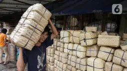 Pedagang membawa besek bambu di Pasar Jatinegara, Jakarta, Kamis (1/7/2021). Menurut pedagang, penjualan besek untuk daging kurban jelang Idul Adha 2021 diharapkan mengalami peningkatan, mengingat kebijakan Pemprov DKI melarang penggunaan kantong plastik sekali pakai. (Liputan6.com/Faizal Fanani)