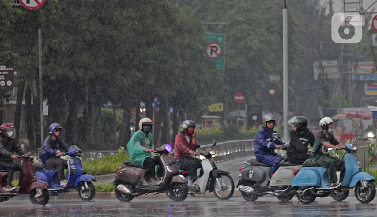 Pengendara sepeda motor menggunakan jas hujan saat berkendara di kawasan Bundaran HI, Jakarta, Minggu (24/1/2021). Badan Meteorologi Klimatologi dan Geofisika (BMKG) mencatat sebagian besar wilayah Indonesia telah memasuki masa puncak musim hujan. (Liputan6.com/Herman Zakharia)