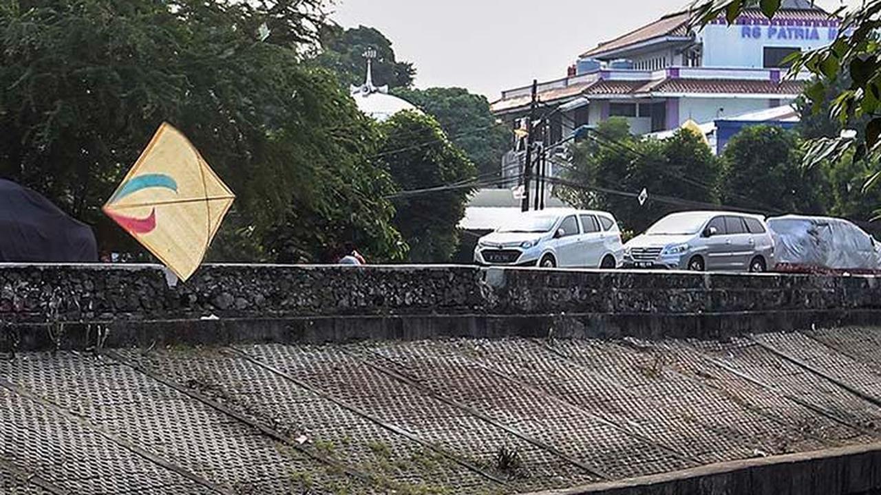 FOTO: Ruang Terbuka Hijau Minim, Anak-Anak di Jakarta Main Layang-Layang di Pinggir Kali