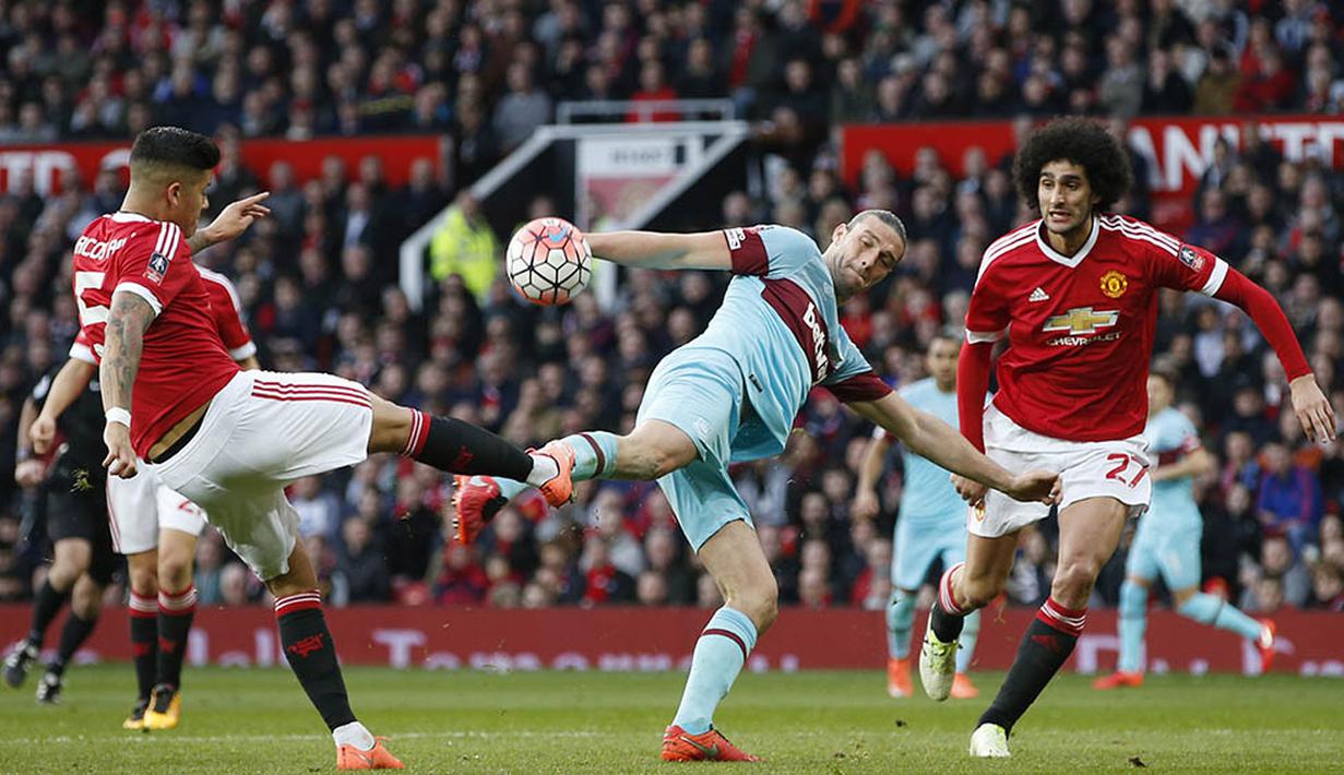 Striker West Ham, Andy Carroll, berebut bola dengan bek Manchester United, Marcos Rojo. MU lebih menguasai jalannya laga dengan penguasaan bola 52 persen. (Reuters/Andrew Yates)