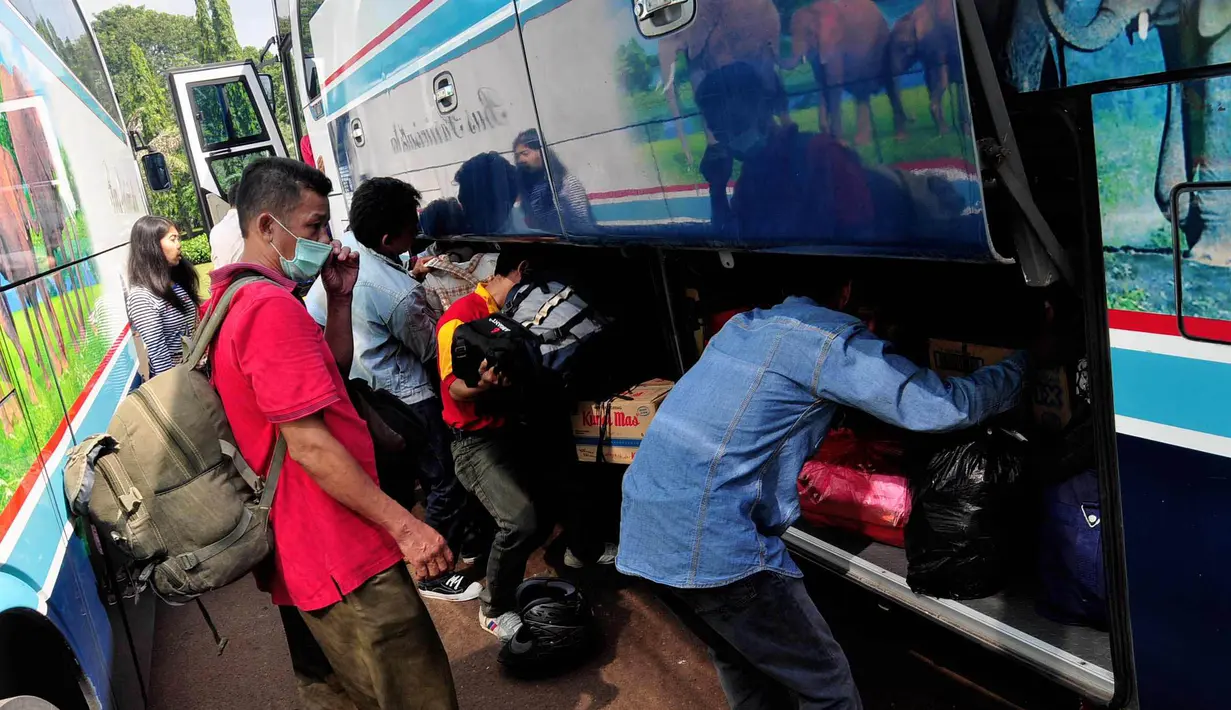 Para penumpang memasukkan barangnya ke dalam bagasi bus. Jakarta, Kamis (24/7/14) (Liputan6.com/Faizal Fanani)