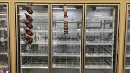 Rak susu sebagian besar kosong di toko kelontong Giant, Washington, Selasa (11/1/2022). Varian Omicron yang sangat menular membuat pekerja sakit, menciptakan kekurangan tenaga kerja yang memengaruhi pengiriman produk dan pengisian kembali rak-rak toko di seluruh negeri. (AP Photo/Parker Purifoy)