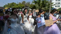 Wanita Myanmar memakai gaun pengantin memegang plakat selama demonstrasi menentang kudeta militer 1 Februari di Yangon (10/2/2021). (AFP/ Ye Aung Thu)
