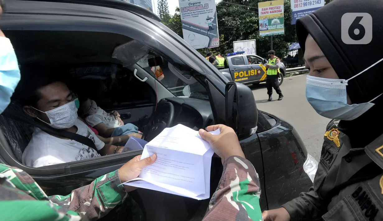 Petugas gabungan Satgas COVID-19 memeriksa surat rapid test antigen pengguna kendaraan di jalur wisata Puncak, Gadog, Bogor, Jawa Barat, Jumat (12/2/2021). Pemeriksaan dan penyekatan sebagai upaya meminimalisir penyebaran COVID-19 saat libur Imlek 2572 dan akhir pekan. (merdeka.com/Arie Basuki)